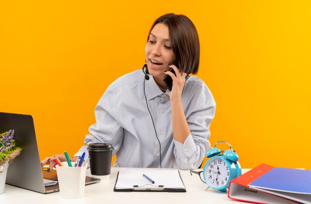 Top 10 Cold Calling Services in Virginia 2025 2 joyful young call center girl wearing headset sitting desk talking phone using laptop isolated orange 141793 84174