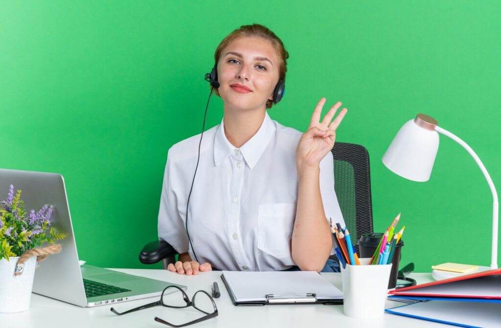 Top 10 Telemarketing Services in California for 2025 3 pleased young blonde call centre girl wearing headset sitting desk with work tools showing three with hand 141793 112032