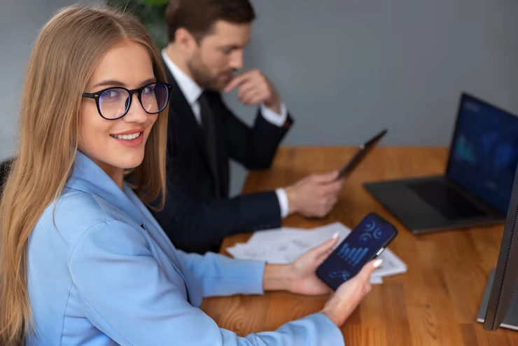 Professional woman using mobile device for cybersecurity pay per lead services in modern office setting