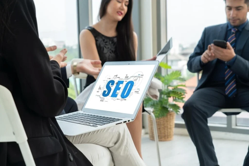 Lead Generation Agency New York 33 Business professionals discussing SEO strategy with laptop displaying SEO optimization concepts