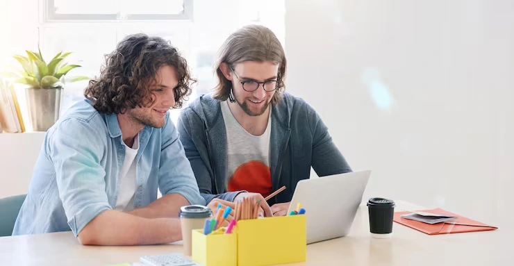 Two people collaborating on a laptop.