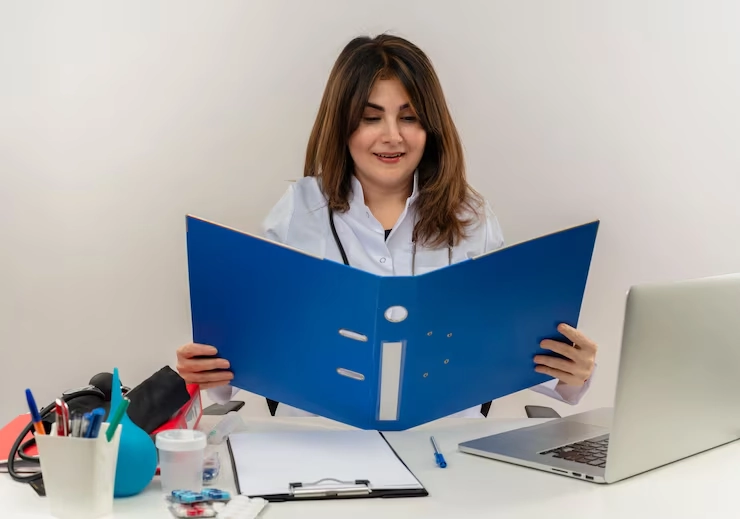 Email Marketing For Healthcare 35 Healthcare marketing specialist reviewing HIPAA compliance documentation at desk with laptop and materials
