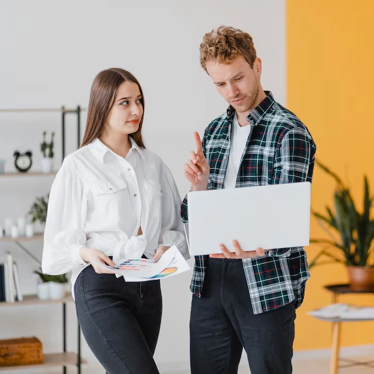 Discussing ideas with documents and laptop.